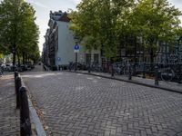 bike racks line a road with parked bicycles in the distance on an old brick road