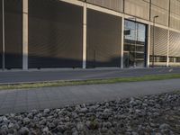 a young man riding his bike down the street near a building in front of it