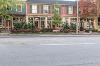 a woman is riding her bike down the street in front of several building with windows