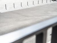 a person riding a bike on a paved area near street and a motorcycle racking area