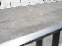 a person riding a bike on a paved area near street and a motorcycle racking area