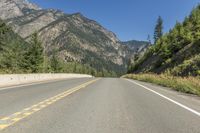 a bike sits on the side of the road near trees and rocks a mountain range