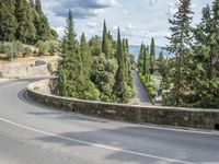 a bike and scooter riding down the side of a curvy road