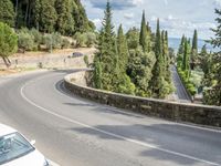 a bike and scooter riding down the side of a curvy road