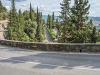 a bike and scooter riding down the side of a curvy road