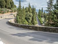 a bike and scooter riding down the side of a curvy road