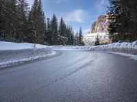 a person riding a bike on a snow covered road near a mountain peak in the background