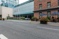 people are riding bikes down a paved street next to an office building with tall windows