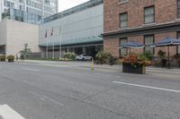 people are riding bikes down a paved street next to an office building with tall windows