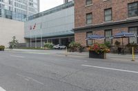 people are riding bikes down a paved street next to an office building with tall windows