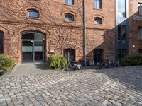 there are many bikes standing outside of this building in front of a door and some windows