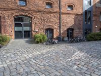 there are many bikes standing outside of this building in front of a door and some windows