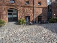 there are many bikes standing outside of this building in front of a door and some windows