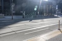 a couple of bikes are parked on a road side near a tall building, and a bike rack in the center of it