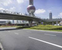 the man is riding his bike through the bridge, in front of oriental architecture and people walking