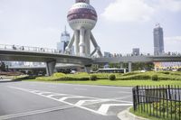 the man is riding his bike through the bridge, in front of oriental architecture and people walking