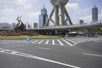 the man is riding his bike through the bridge, in front of oriental architecture and people walking