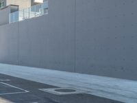 two people are riding their bikes down the road in front of a building at an intersection