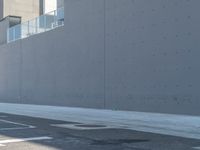 two people are riding their bikes down the road in front of a building at an intersection