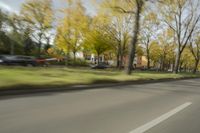 a guy riding his bike down an empty road with lots of trees behind him in a blurry photo