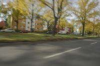 a guy riding his bike down an empty road with lots of trees behind him in a blurry photo