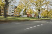 a guy riding his bike down an empty road with lots of trees behind him in a blurry photo