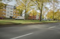 a guy riding his bike down an empty road with lots of trees behind him in a blurry photo
