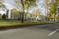 a guy riding his bike down an empty road with lots of trees behind him in a blurry photo