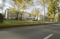 a guy riding his bike down an empty road with lots of trees behind him in a blurry photo