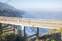 the bridge over the ocean is elevated and looks out to the beach and a sea