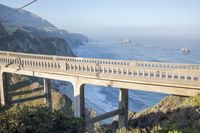 the bridge over the ocean is elevated and looks out to the beach and a sea