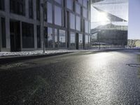 the sun shines through the glass facade and windows above the sidewalk in a city