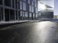 the sun shines through the glass facade and windows above the sidewalk in a city