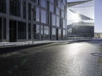 the sun shines through the glass facade and windows above the sidewalk in a city