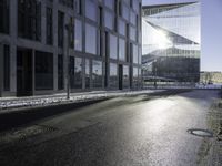 the sun shines through the glass facade and windows above the sidewalk in a city