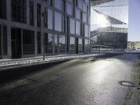 the sun shines through the glass facade and windows above the sidewalk in a city