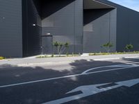 a black and white building with tree in the middle of it and a parking lot