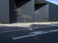 a black and white building with tree in the middle of it and a parking lot