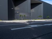 a black and white building with tree in the middle of it and a parking lot