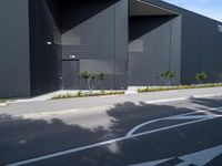 a black and white building with tree in the middle of it and a parking lot