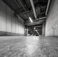 there is a black and white photo in the garage of a building with concrete flooring