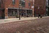 a black and white fire hydrant on a brick road next to buildings with lots of windows