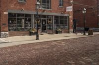 a black and white fire hydrant on a brick road next to buildings with lots of windows