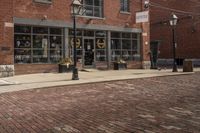 a black and white fire hydrant on a brick road next to buildings with lots of windows