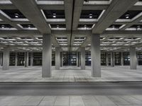 a building with an open walkway and parking meters between it and another parking meter on the right