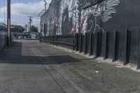 a black and white mural on the side of a building near a walkway with a red light