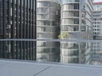 black building reflecting off the water on the edge of a city canal with a man and woman