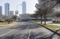 a black car drives along a deserted road in front of the modern building behind it