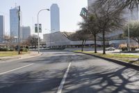 a black car drives along a deserted road in front of the modern building behind it