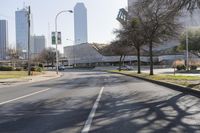 a black car drives along a deserted road in front of the modern building behind it